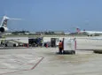 Ground support equipment at the airport including baggage being placed on an aircraft