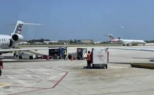 Ground support equipment at the airport including baggage being placed on an aircraft