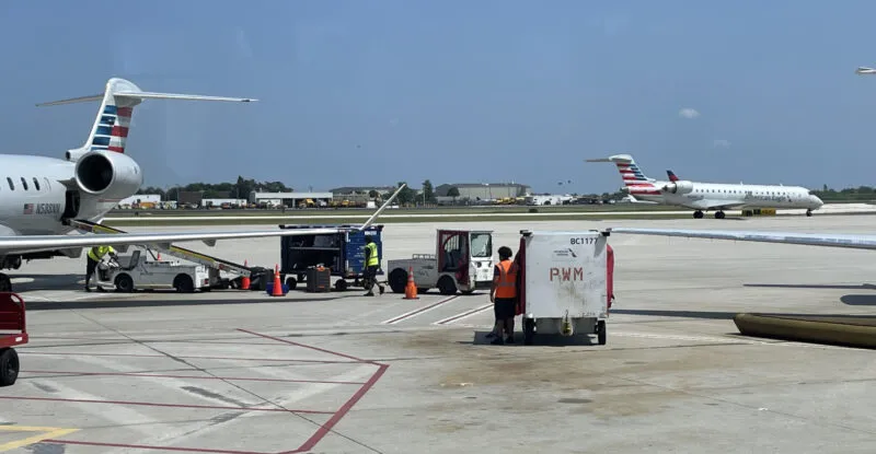 Ground support equipment at the airport including baggage being placed on an aircraft