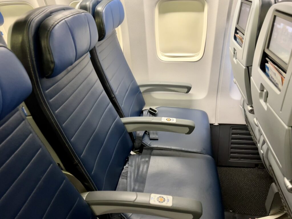 United Airlines Boeing 737-800 seat triple in economy with blue seat covers