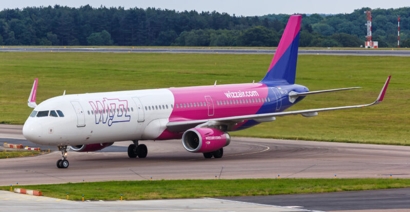 Wizz Air A321 in its pink, white and blue livery at Luton Airport. A Wizz Air A321 is fitted with the fflya Bluetooth connectivity system, which talks to Iridium NEXT satellites via unique window antennas.