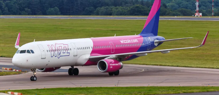 Wizz Air A321 in its pink, white and blue livery at Luton Airport. A Wizz Air A321 is fitted with the fflya Bluetooth connectivity system, which talks to Iridium NEXT satellites via unique window antennas.