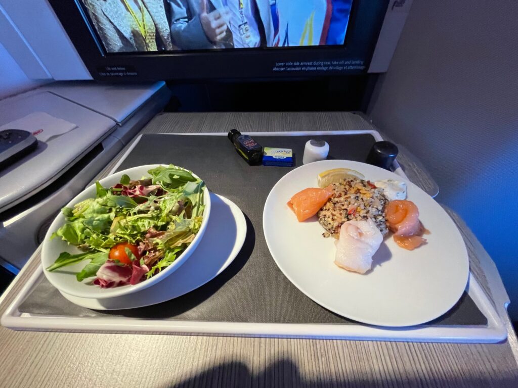 Air Canada Inflight meal with a salad and a seafood dish displayed on the tray table