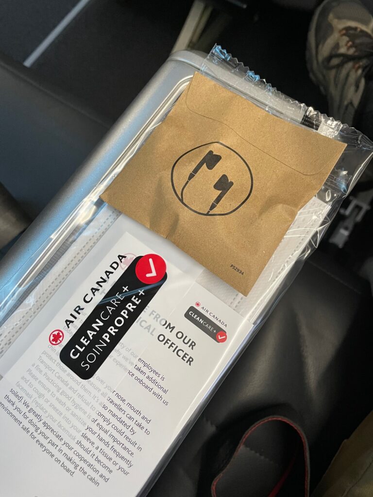 A packet of earphones and a "CleanCare+" sanitary kit from Air Canada