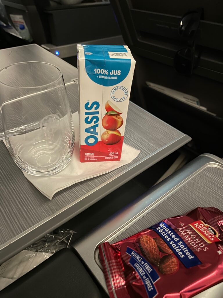 A small carton of apple juice on the tray table