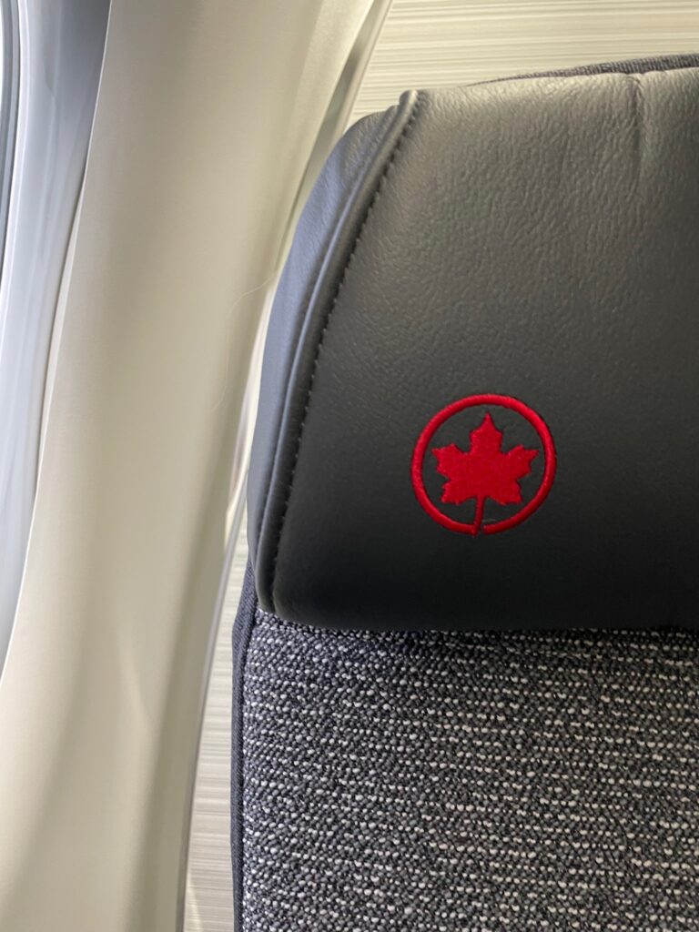 A red maple leaf stitched into the corner of the business class seat