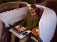 A man is using his laptop in business class on a Singapore Airlines SIA flight
