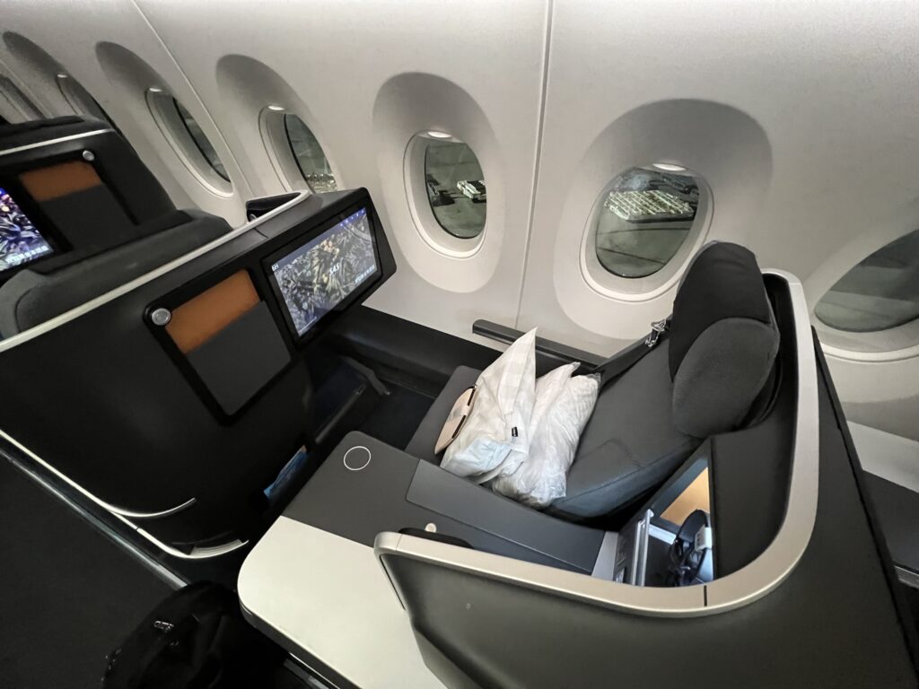 A top-down view of the SAS business class seat, with a pillow and blanket set waiting on the seat