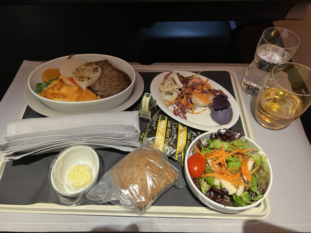 SAS business class meal with steak and a salad, plus a bread role and seafood side