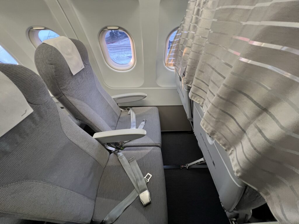 Finnair Airbus A319 economy class seat, with curtain dividing economy and business in the scene