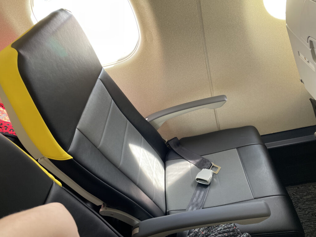 Breeze aircraft seat is a mixture of black and grey with details of yellow. The window seat pictured here is empty.