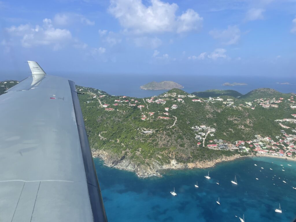 Looking out the window of a Pilatus C-12 over a crystal blue ocean and beaches of an island. 