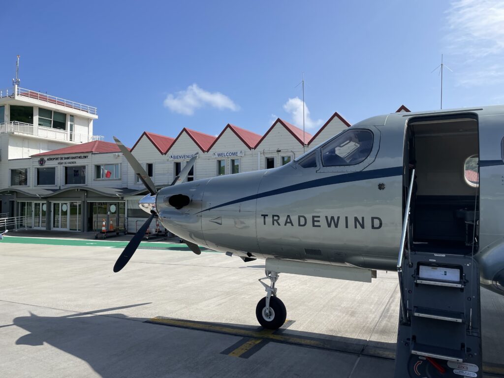 A Pilatus PC-12 sits open for passengers to exit at the small island airport.