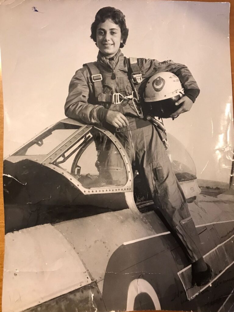 Senay Günay standing in her aircraft holding her helmet.