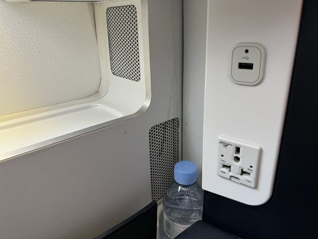 A water bottle is tucked away near two charging ports.