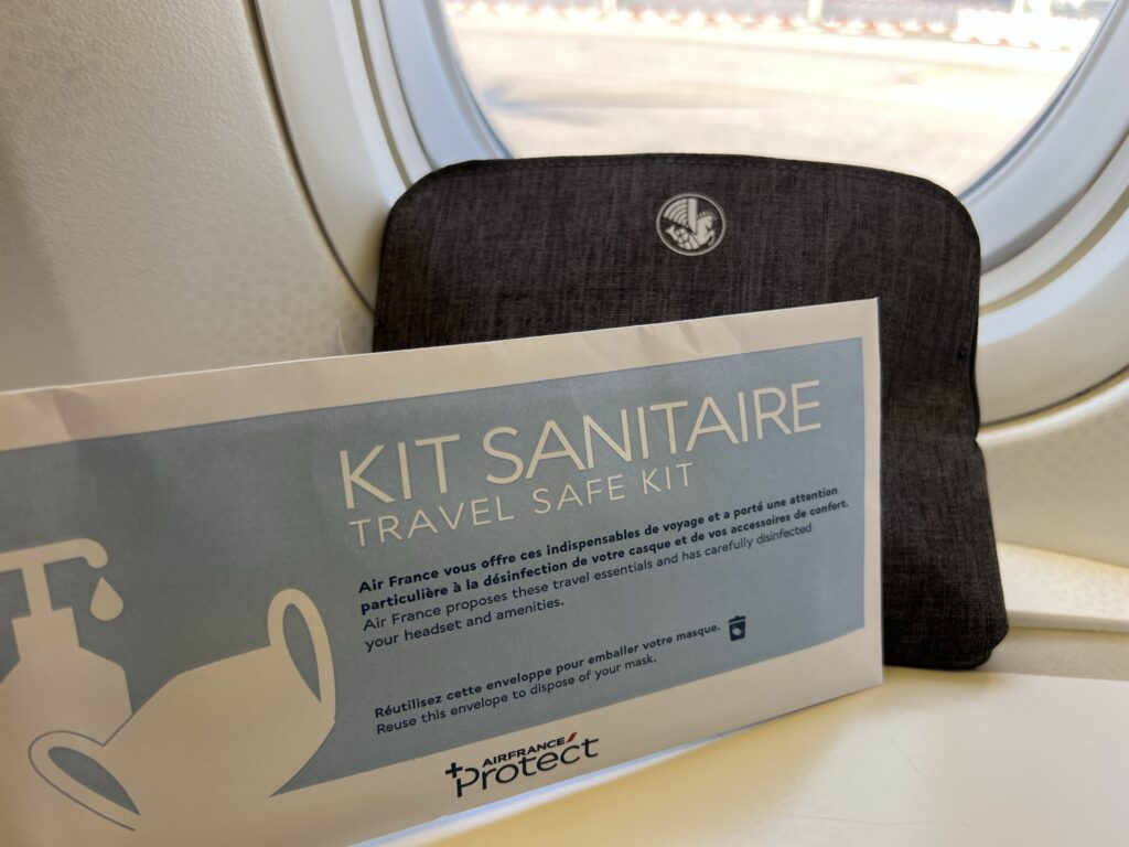 Sanitization kit given by Air France to the passengers. The kit is displayed in front of the aircraft window.