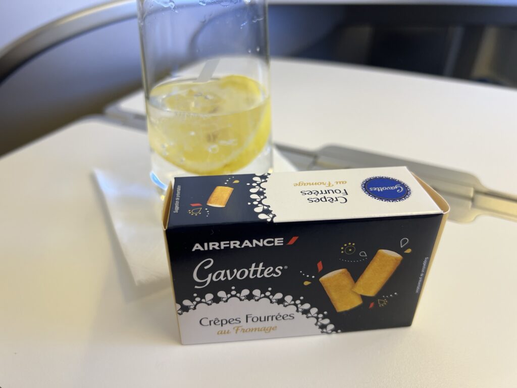 A boxed snack and drink sit displayed on an aircraft table.