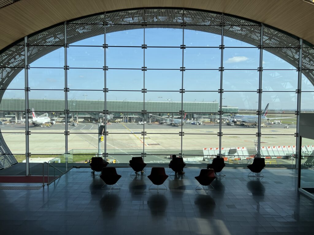 Les murs du sol au plafond donnent sur la piste et les pistes de l'aéroport.  Les sièges télescopiques font face à la fenêtre pour que les passagers puissent profiter de la vue.