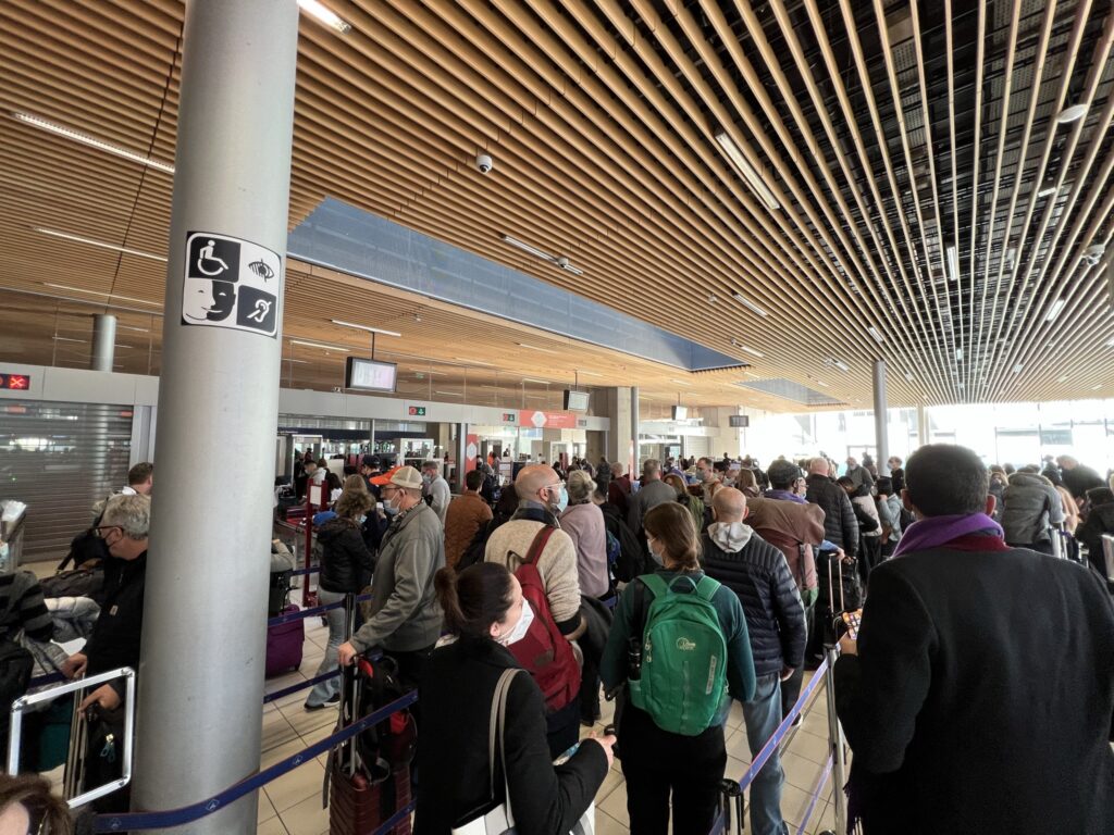 A crowd of people lined up in an airport. 