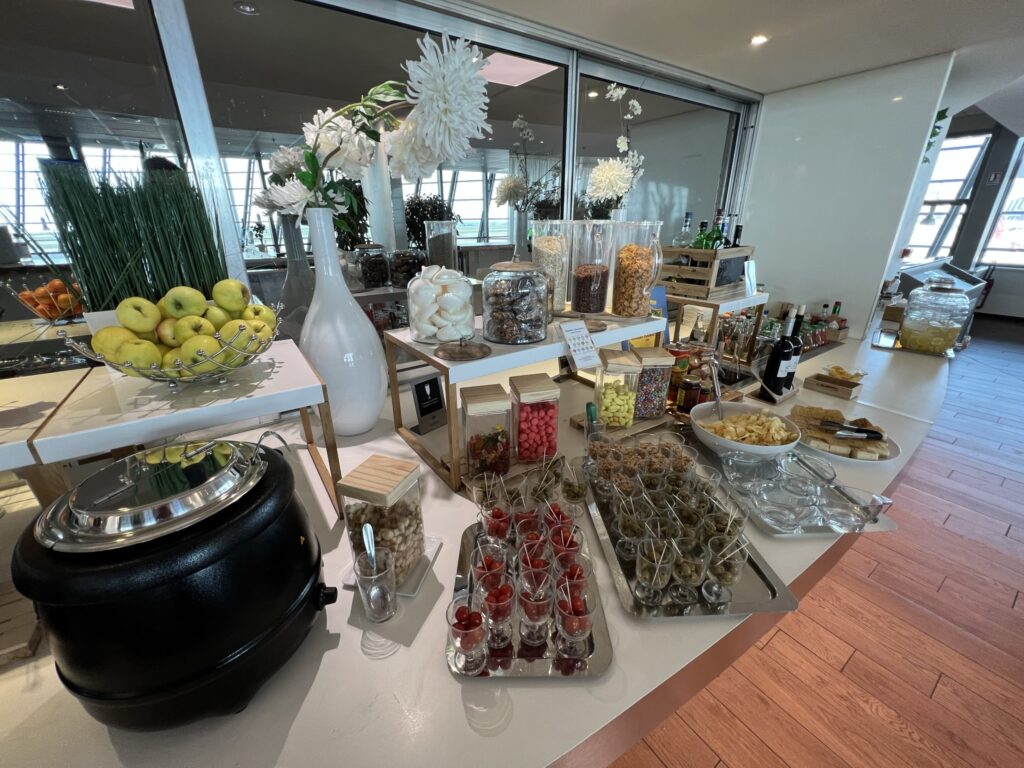 An array of food is sitting on a buffet table in the Air France lounge.