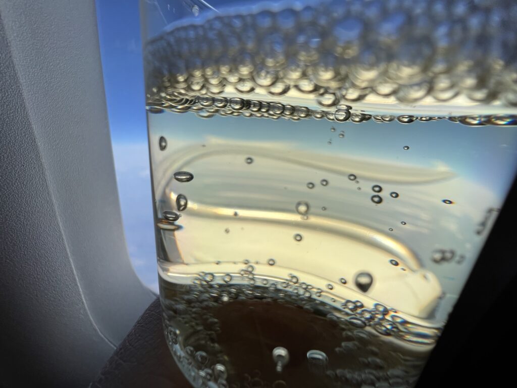 Holding up a champers with the window seat as backdrop