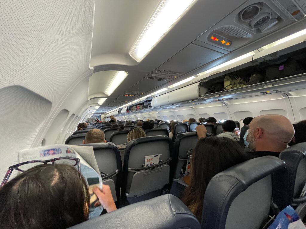 Allegiant Airbus A319 with passengers. This photo shows a sea of gray seatbacks.