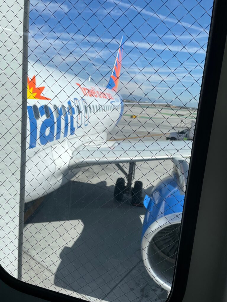 Allegiant Airbus A319 from the airport window. The aircraft is parked at the gate.