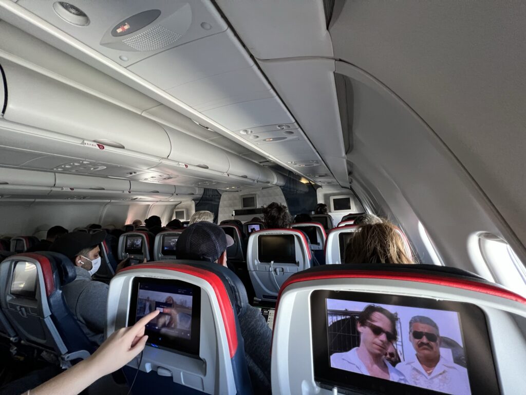 A passenger is trying to use the touch screen embedded IFE.