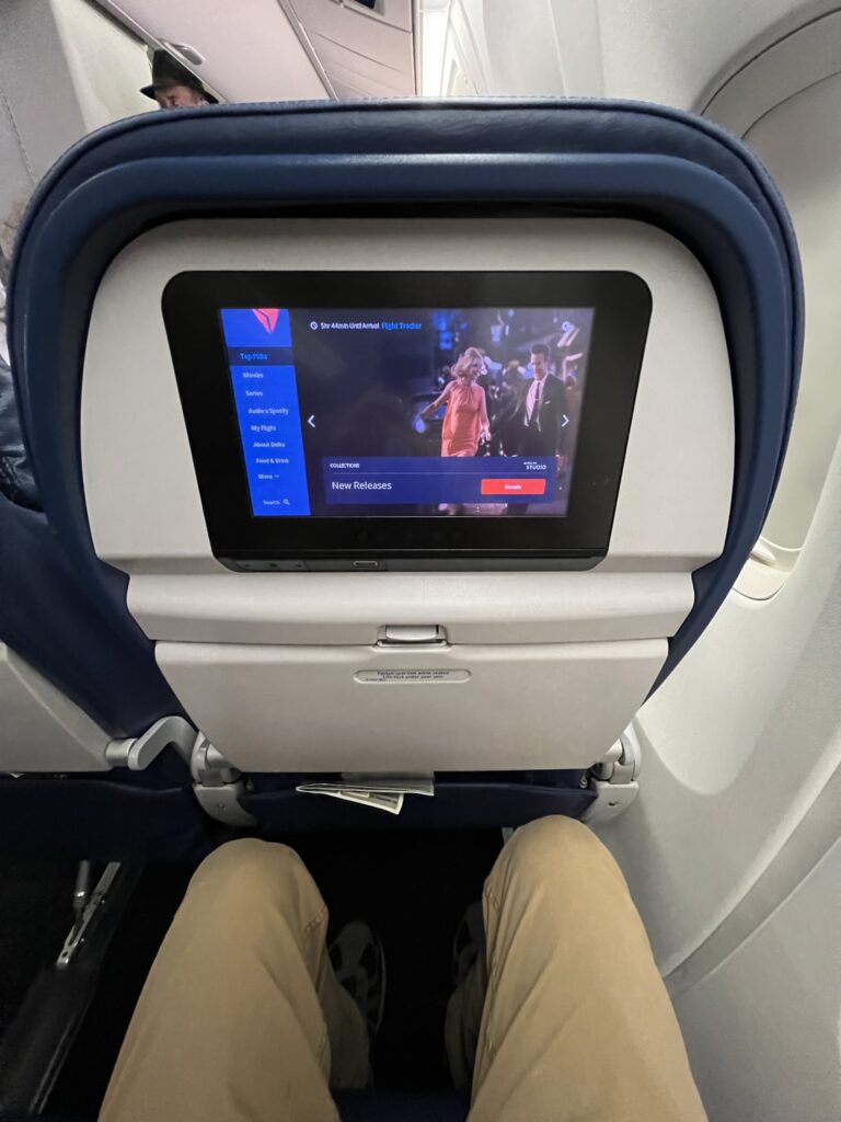 Delta Air Lines Boeing 767-300ER embedded IFE screen. A man's knees are also shown in the image.