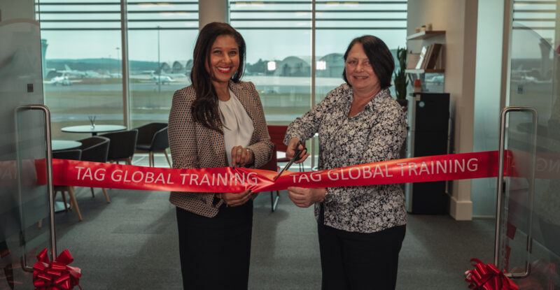 Debbie Elliott, TAG Global Training Manager (left) and Joanne Goodall, CEO TAG Aviation Europe symbolically cutting a large red ribbon.