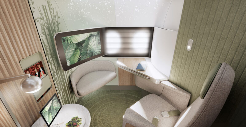 Teague's Elevate business class seat attached to the aircraft via a Ebrace is pictured here. The area is spacious with a marble table, IFE screen, large window and sage green accents along with Bamboo fixtures.