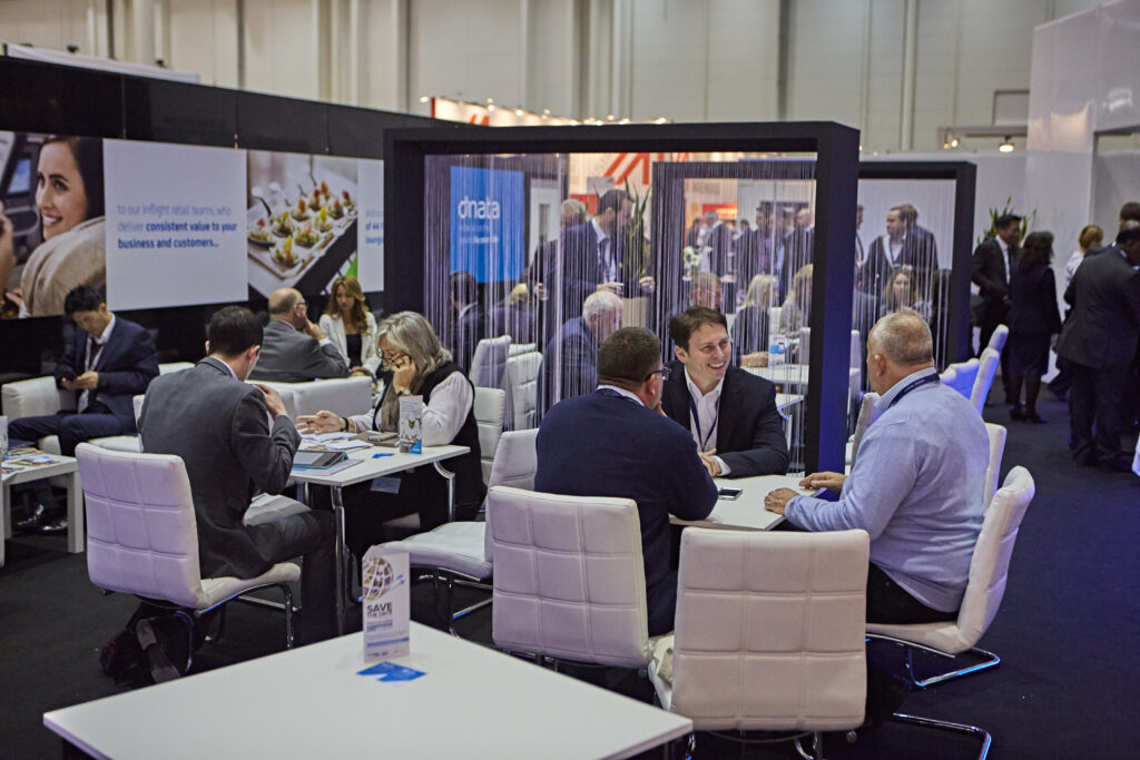 People are sitting at various tables enjoying conversation and food.