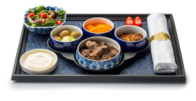 KLM World Business Class displayed on a black tray. the tableware have intricate blue details.