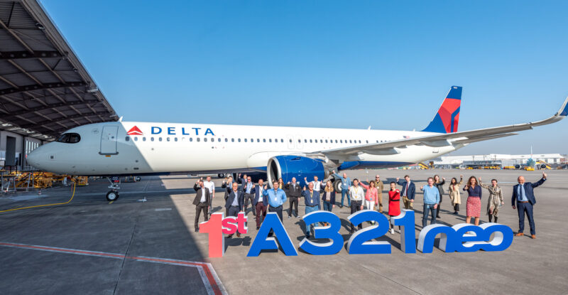 Delta a321neo is pictured with a large group of employees in front of it and big lettering making up the word A321NEO.