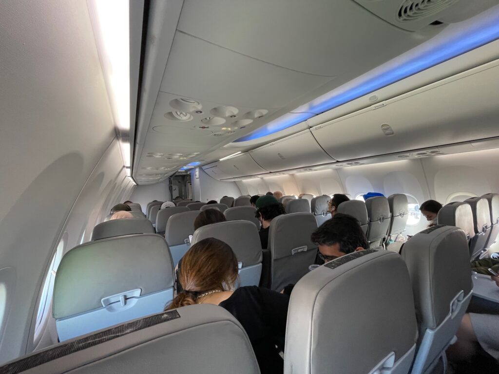 Flair Airline Boeing 737 MAX 8 cabin interior is most grey with blue LED lighting running along the overhead bins.