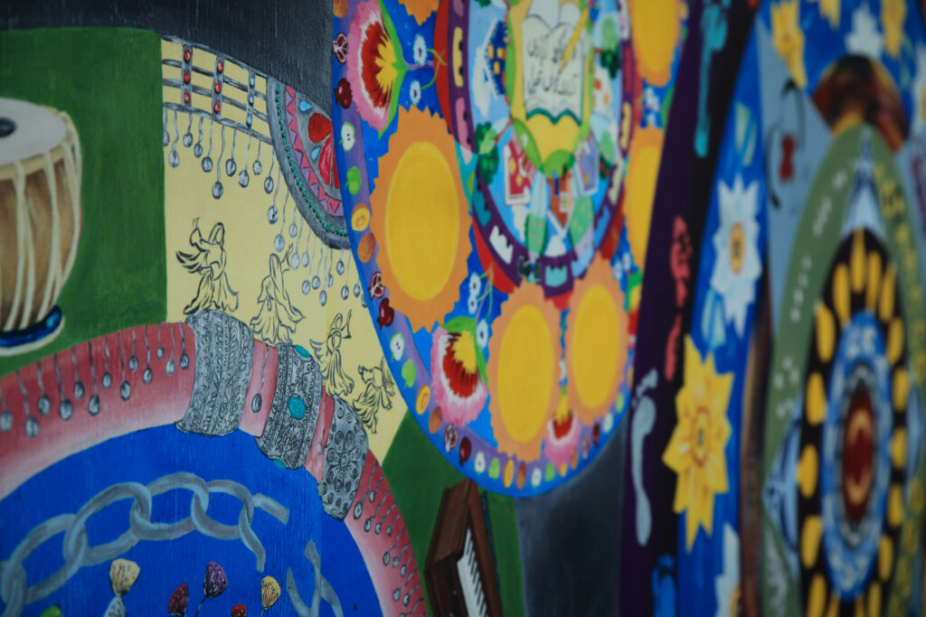 A colorful mural that has a mandala style of patterning.