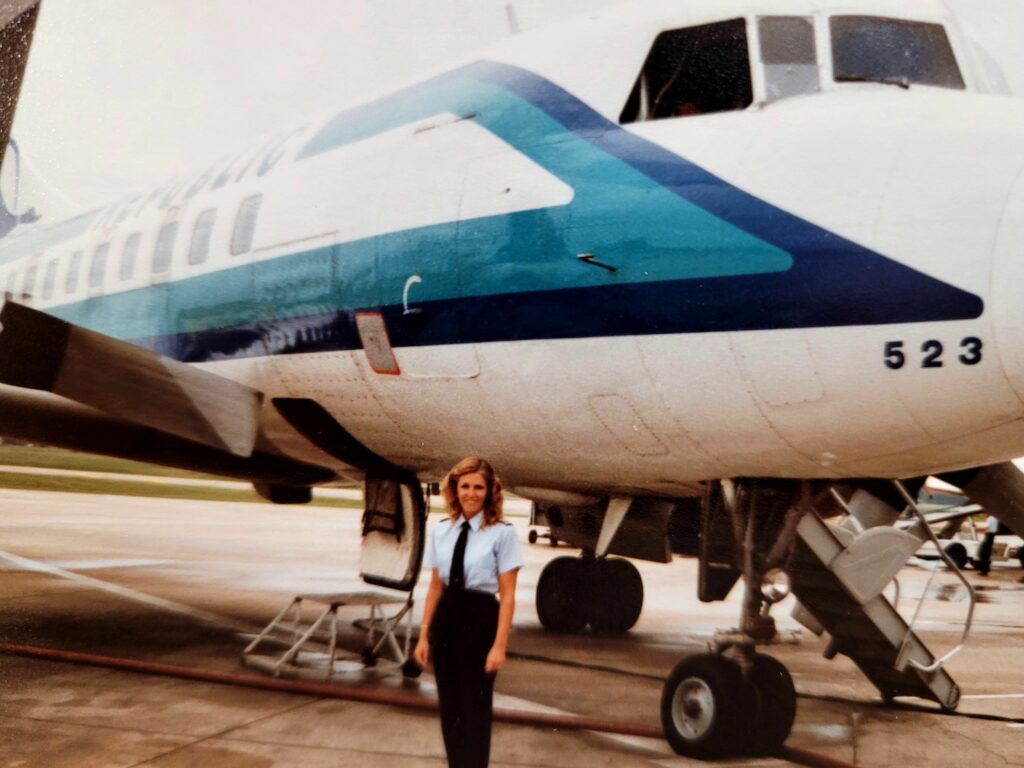 Pam Almand is standing in front of a Republic aircraft. 