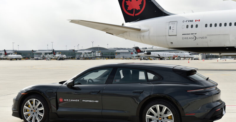 A Porsche is parked next to an Air Canada aircraft