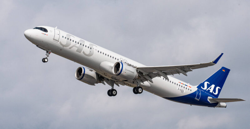 SAS Airbus A320 in flight on a cloudy day.