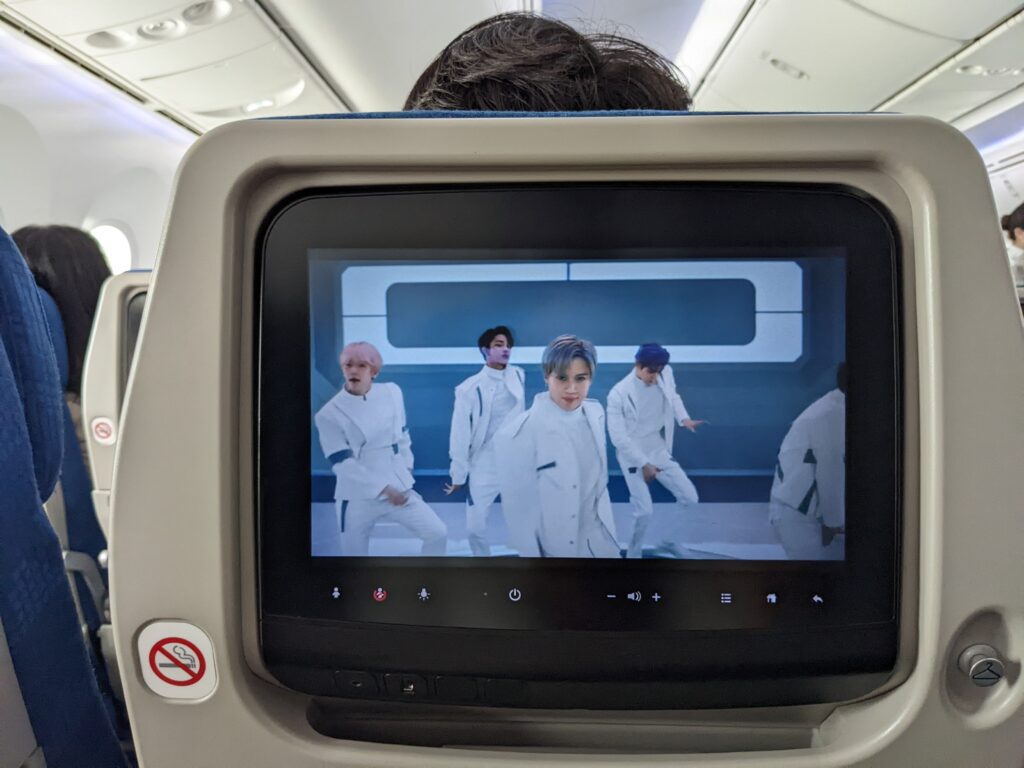 IFE screen embedded in the economy class seat of Korean Air 787. The screen is displaying the safety video.