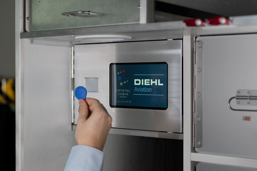 A hand is holding up a electronic key for Diehl's smart lock system.