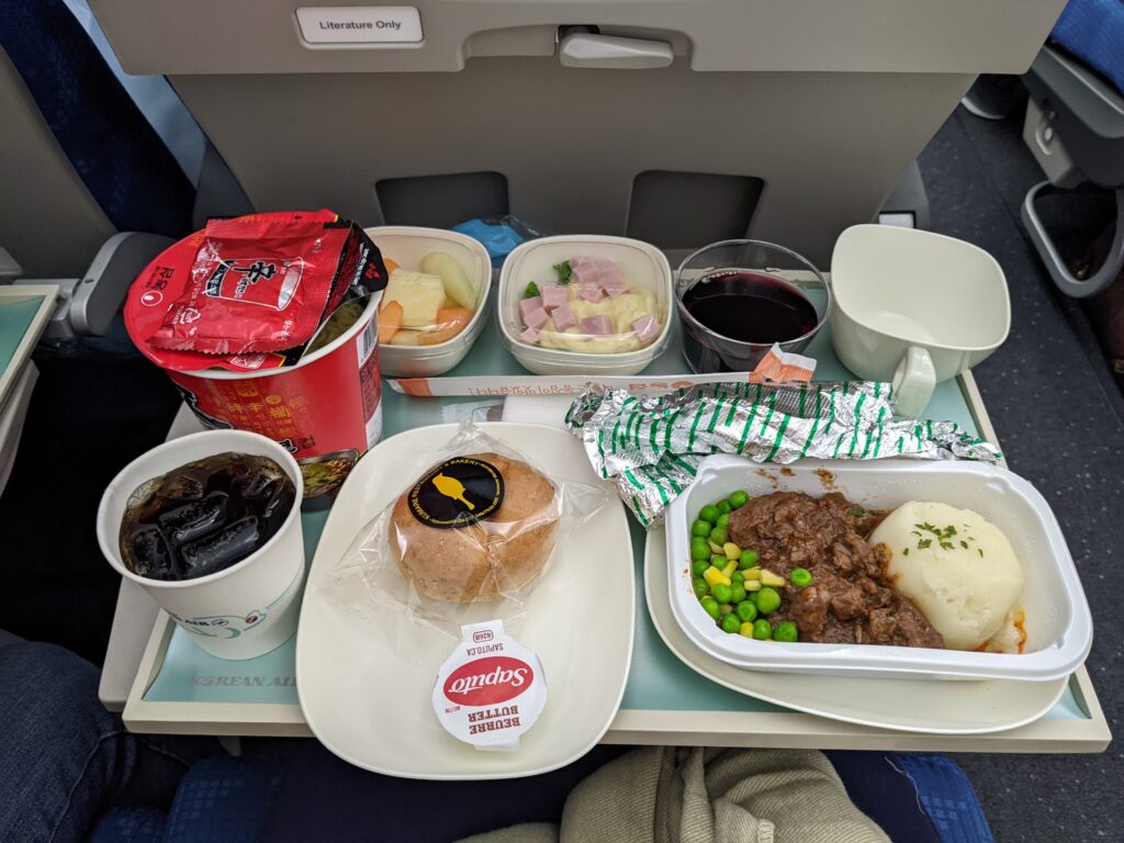 A meal being served on a aircraft economy class tray table