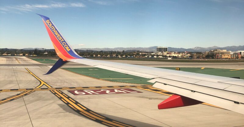 Southwest wingtip with the runway behind it. Travel in the United States