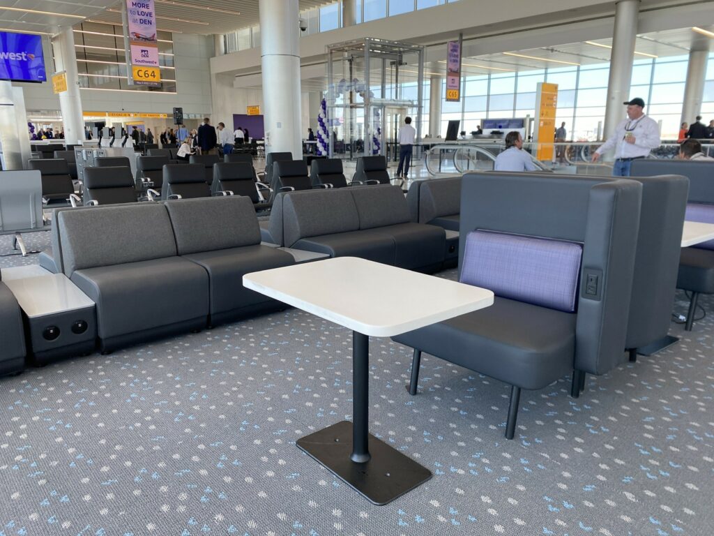 Couch-like sitting area with a table for working at in the new Southwest terminal at DEN