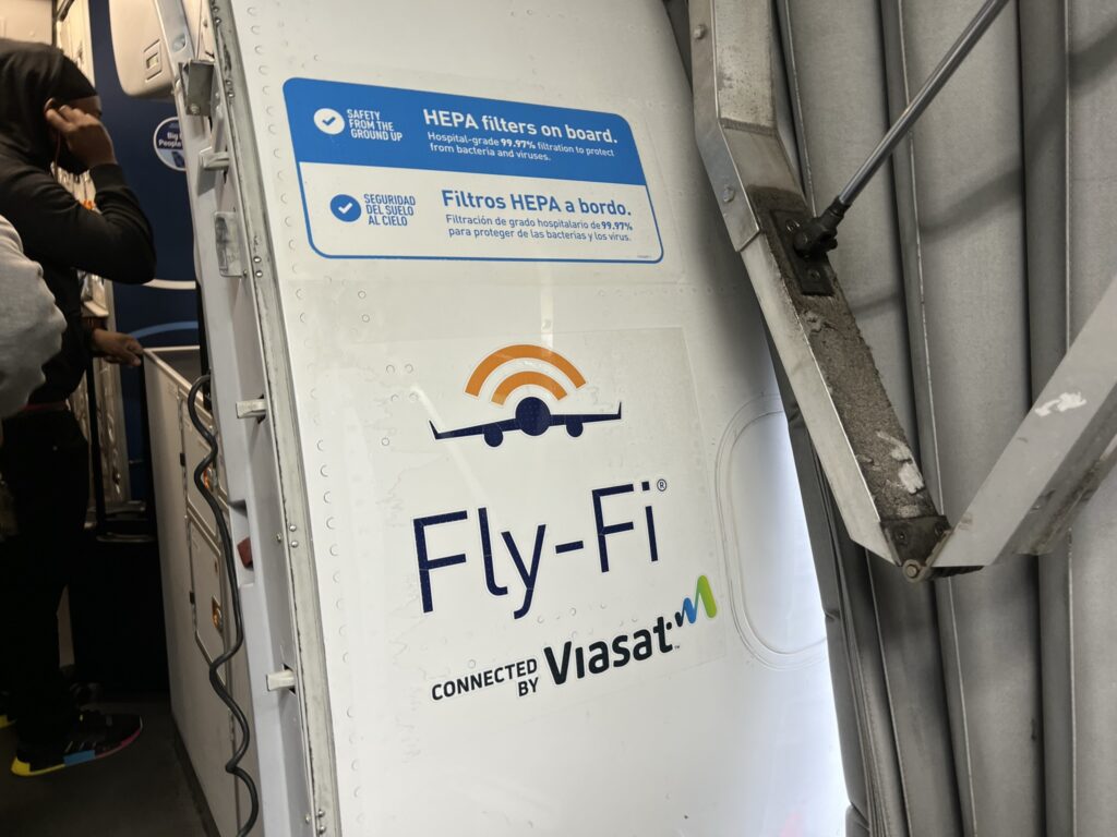 FlyFi logo on the side of the aircraft near the entry door.