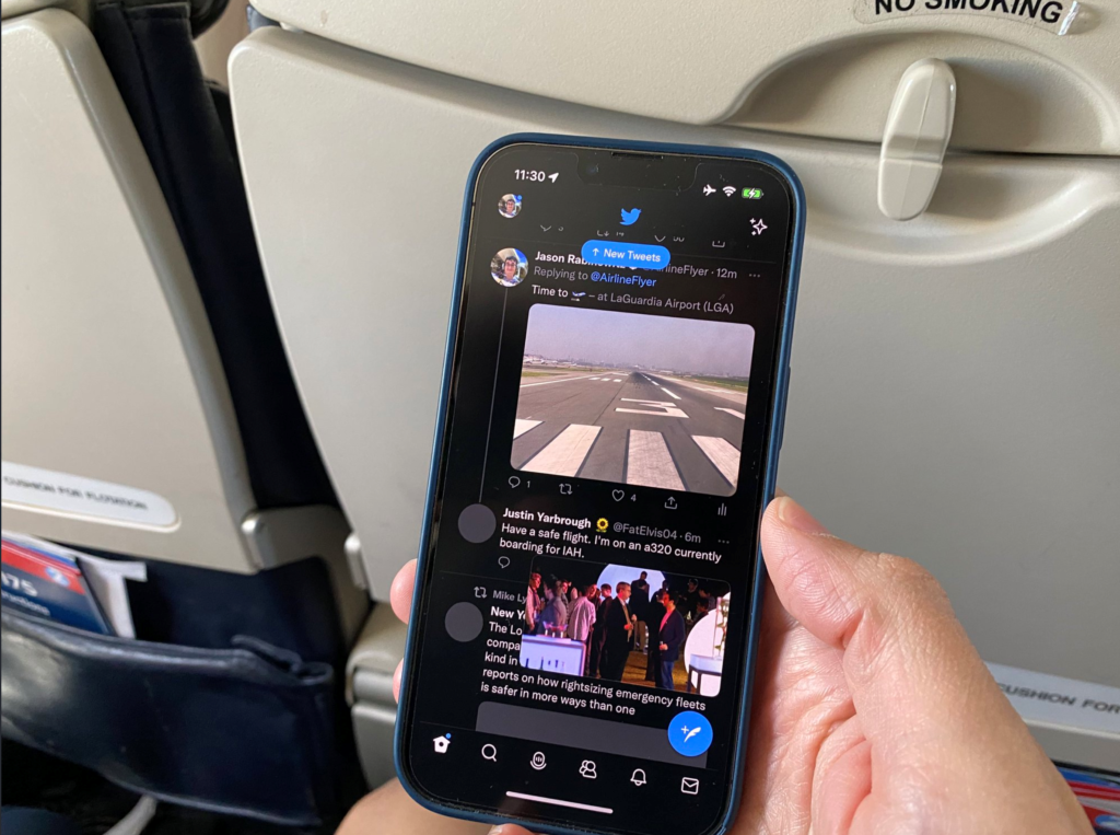 A man holds his mobile and observes the picture-in-picture content onboard