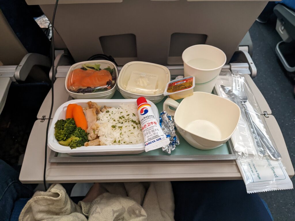 A meal being served on a aircraft tray table