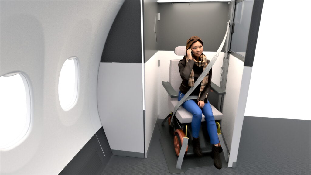 A woman is on her mobile device while sitting in a wheelchair in the Fly Your Wheels Suite.