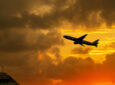 Airplane takeoff from airport with cloudy sky during sunrise