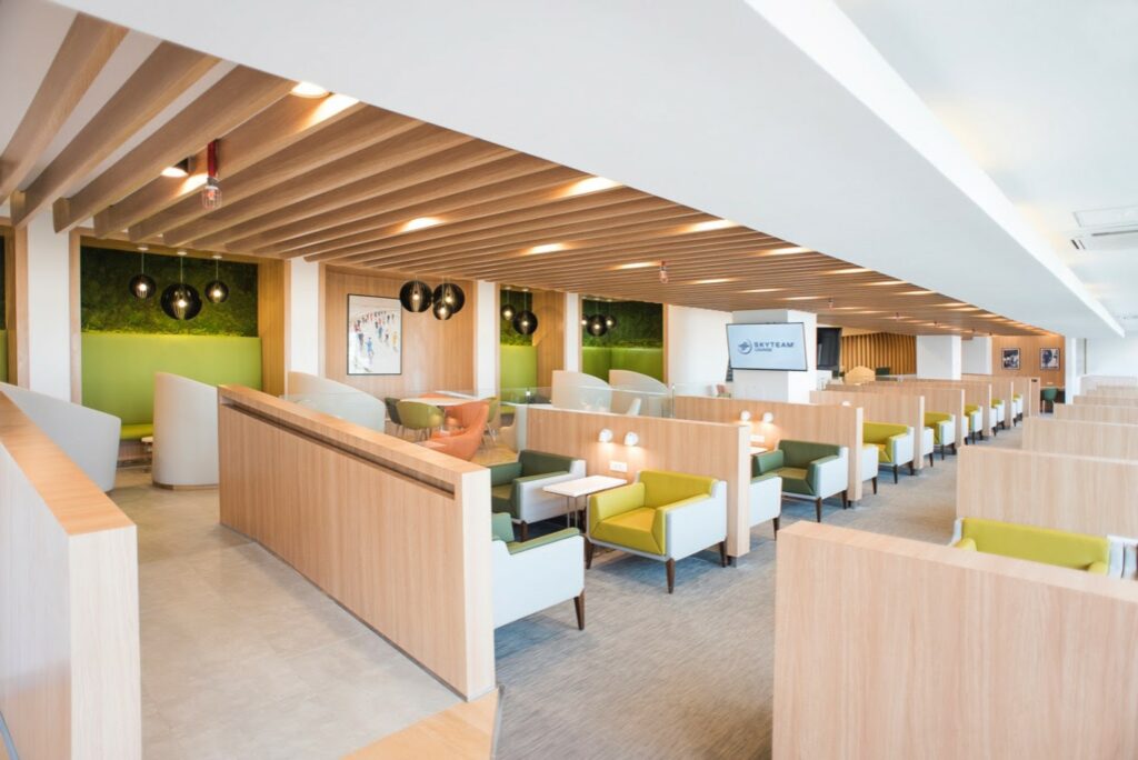 A wide angle view of the greenish lounge seating, with wood accents.